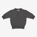 dark grey short-sleeved half-button cashmere sweater, laid flat.